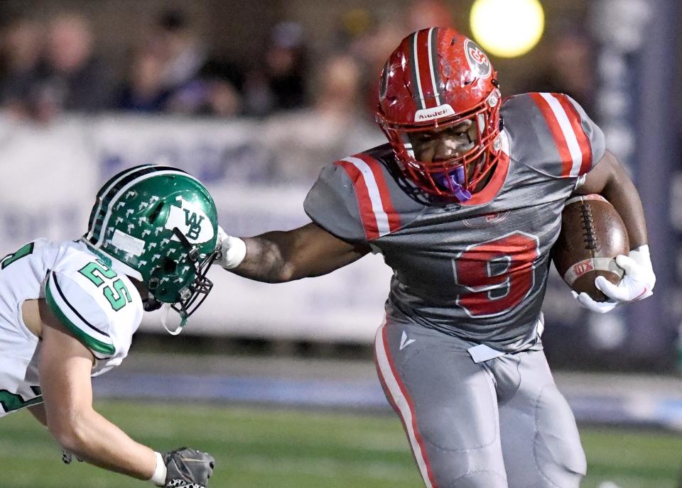 Canton South running back Rome Cox holds off West Branch defender Clayton Day in the second quarter of Division IV regional semifinal at Louisville Leopard Stadium. Friday, Nov. 10, 2023.