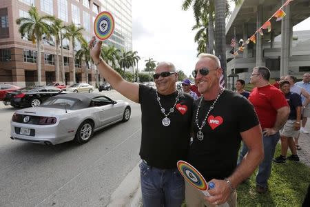Terry Decarlo (L) and Bill Huelsman of Wilton Manors take part in a rally by gay rights activists following the U.S. Supreme Court's 5-4 ruling, striking down as unconstitutional the Defense of Marriage Act (DOMA), in Fort Lauderdale, Florida June 26, 2013. REUTERS/Joe Skipper