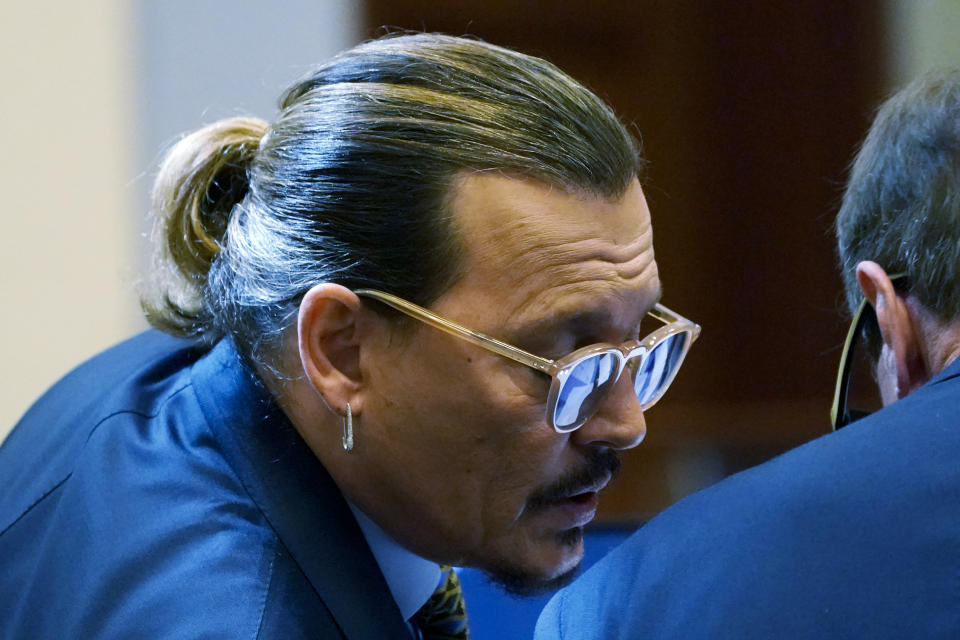 Actor Johnny Depp talks to his attorney Ben Chew, in the courtroom at the Fairfax County Circuit Courthouse in Fairfax, Va., Monday, May 23, 2022. Depp sued his ex-wife Amber Heard for libel in Fairfax County Circuit Court after she wrote an op-ed piece in The Washington Post in 2018 referring to herself as a "public figure representing domestic abuse." (AP Photo/Steve Helber, Pool)