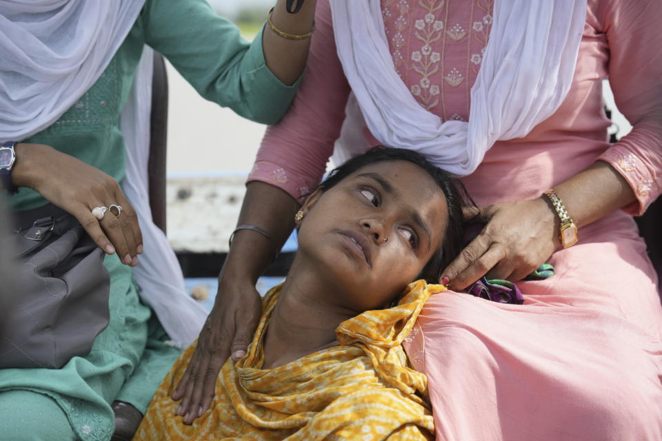 25-year-old Jahanara Khatoon, who is at full-term pregnancy, travels on a boat on her way to a health centre, in Sandoh Khaiti Char, in the northeastern Indian state of Assam, Wednesday, July 3, 2024. (AP Photo/Anupam Nath)