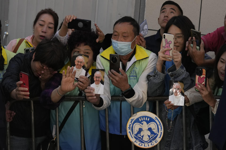 Faithful react as they see Pope Francis leaving in a car after a meeting with charity workers and the inauguration of the House of Mercy in Ulaanbaatar, Monday, Sept. 4, 2023. Francis toured the House of Mercy in the final event of an historic four-day visit to a region where the Holy See has long sought to make inroads. (AP Photo/Ng Han Guan)