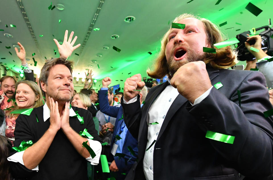 Party leaders Robert Habeck, left, and Anton Hofreiter, right, celebrate on the election party of the Green party in the state parliament in Munich, Germany, Sunday, Oct. 14, 2018, after the polling stations for the Bavarian state elections have closed. (AP Photo/Kerstin Joensson)