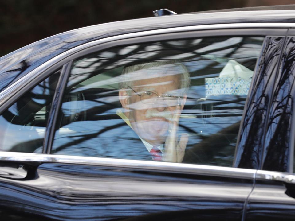 Former National security adviser John Bolton waves as he leaves his home in Bethesda, Md. Tuesday, Jan. 28, 2020.