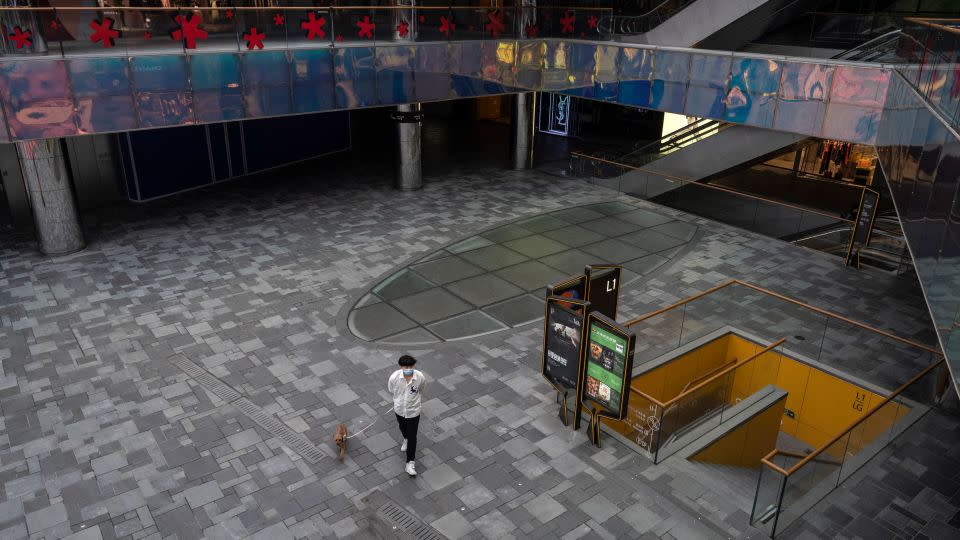 A man walks his dog through a mall during a 2022 Covid shutdown in Beijing, China. - Kevin Frayer/Getty Images