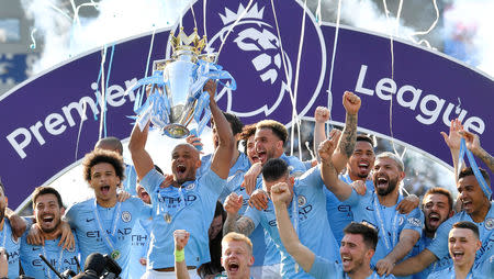 Soccer Football - Premier League - Brighton & Hove Albion v Manchester City - The American Express Community Stadium, Brighton, Britain - May 12, 2019 Manchester City's Vincent Kompany lifts the trophy as they celebrate winning the Premier League REUTERS/Toby Melville