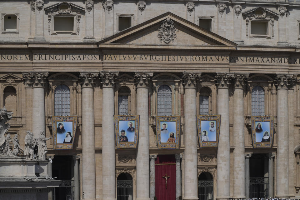 The tapestries depicting ten new saints, from left and top to bottom, Marie Rivier (1768-1838), Maria Francesca di Gesù Rubatto (1844-1904), César de Bus (1544-1607), Luigi Maria Palazzolo (1827-1886), Titus Brandsma (1881-1942), Lazzaro alias Devasahayam (1712-1752), Giustino Maria Russolillo (1891-1955), Charles de Foucauld (1858-1916), Maria di Gesù Santocanale (1852-1923), and Maria Domenica Mantovani (1862-1934) hang in St. Peter's Square at The Vatican, Sunday, May 15, 2022, during their canonization mass celebrated by Pope Francis. Francis created ten new saints on Sunday, rallying from knee pain that has forced him to use a wheelchair to preside over the first canonization ceremony at the Vatican in over two years. (AP Photo/Gregorio Borgia)