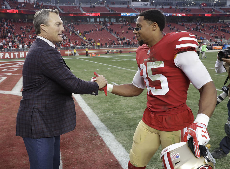 49ers general manager John Lynch (left) greets safety Eric Reid after San Francisco beat the Jaguars last season. (AP)