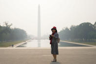 <p>A tourist looks on as haze blankets over the Washington Monument seen at a distance, Wednesday, June 7, 2023, in Washington. Smoke from Canadian wildfires is pouring into the U.S. East Coast and Midwest and covering the capitals of both nations in an unhealthy haze. (AP Photo/Julio Cortez)</p> 