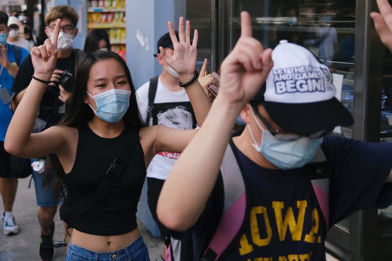 Pro-democracy protesters raise their hands up as a symbol of the "Five demands, not one less" during a march against the looming national security legislation in Hong Kong