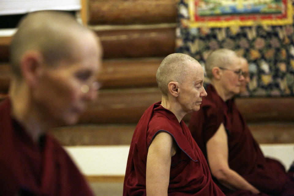 Thubten Samten, center, a fully ordained Buddhist nun, along with other residents and guests sit in mediation during the morning at Sravasti Abbey, Thursday, Nov. 18, 2021, in Newport, Wash. (AP Photo/Young Kwak)