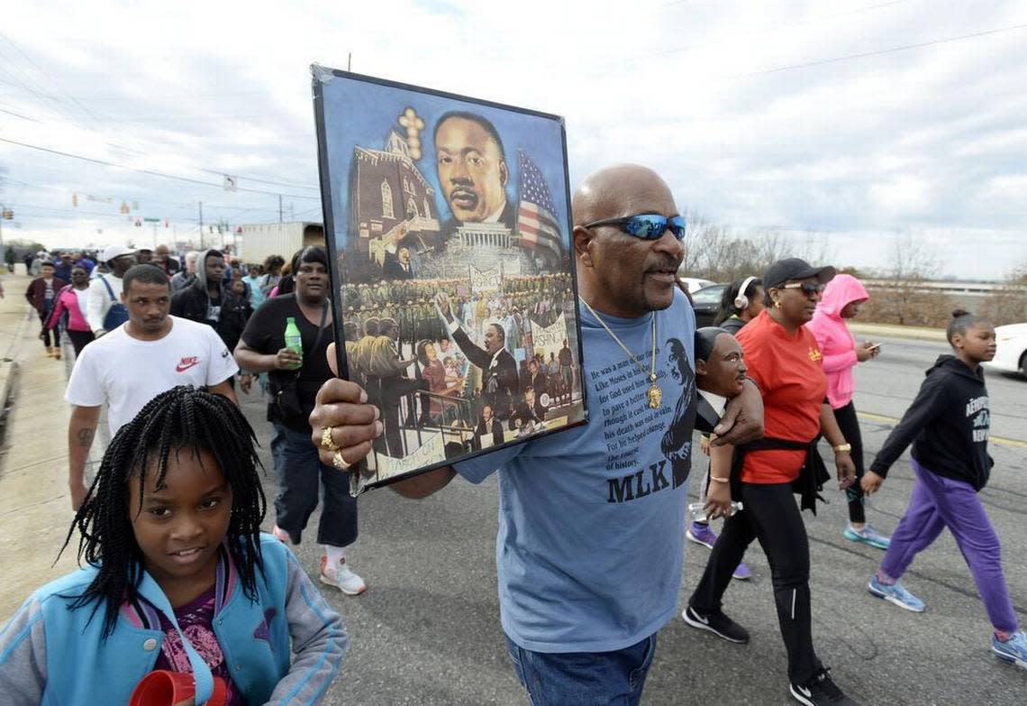 Charlie Williams, center, and his granddaughter Akayla Glover, 8, left, march with hundreds of others celebrating Martin Luther King Jr. Day 2017.