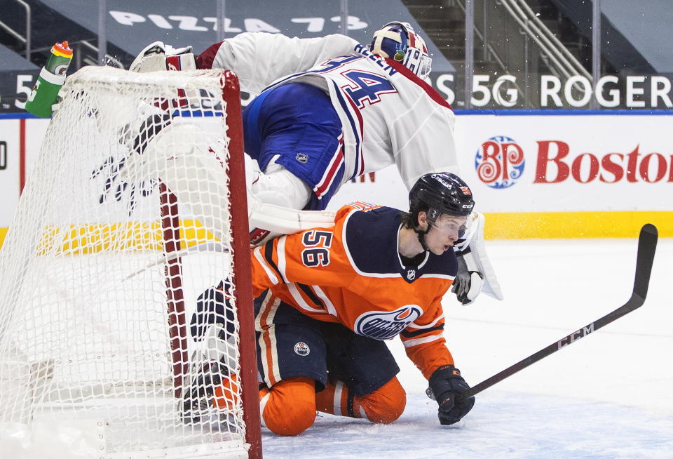 Edmonton Oilers' Kailer Yamamoto (56) crashes into Montreal Canadiens goalie Jake Allen (34) during second-period NHL hockey game action in Edmonton, Alberta, Monday, Jan. 18, 2021. (Jason Franson/The Canadian Press via AP)