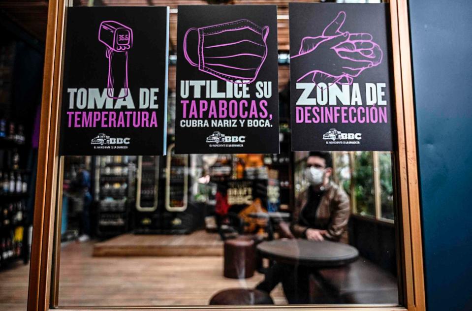 Signs showing preventive measure against the spread of the novel coronavirus, COVID-19 are displayed in a restaurant during a reopening pilot test in Bogota, on July 10, 2020. - From Monday Colombia's capital Bogota will raise its health alert level and impose a "strict quarantine," the city's mayor said on Friday. The capital city of eight million people has recorded 42,000 coronavirus cases, amounting to 32 percent of Colombia's 134,000 infections, and 950 deaths. (Photo by Juan BARRETO / AFP) (Photo by JUAN BARRETO/AFP via Getty Images)