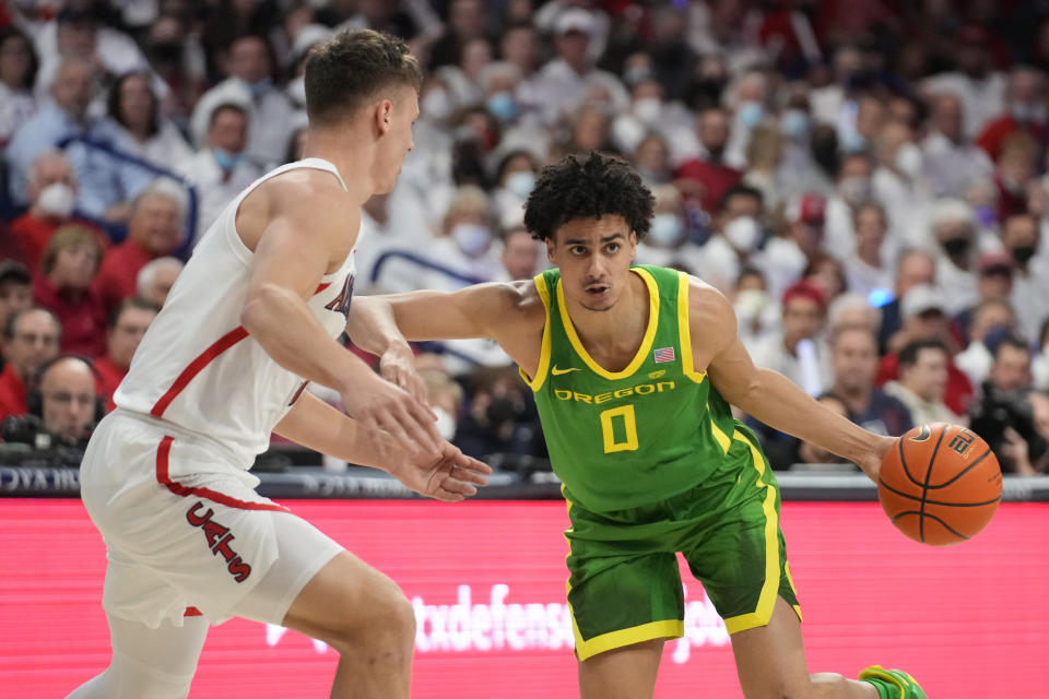 FILE - Oregon guard Will Richardson (0) drives against Arizona guard Pelle Larsson, left, during the first half of an NCAA college basketball game Feb. 19, 2022, in Tucson, Ariz. Streaky-shooting guard Richardson is back and expected to take on a leadership role. (AP Photo/Rick Scuteri, File)