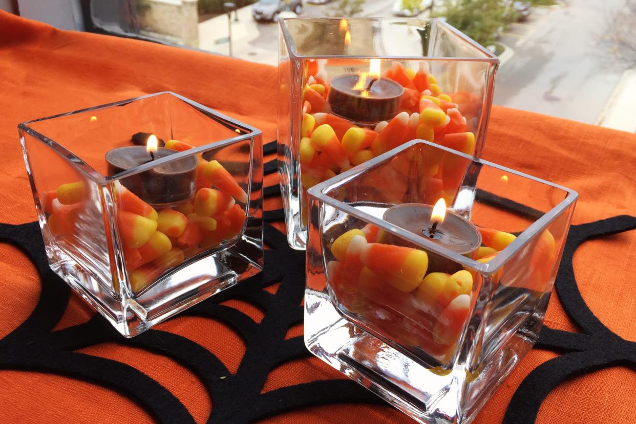 Three candy corn candles making up a centerpiece