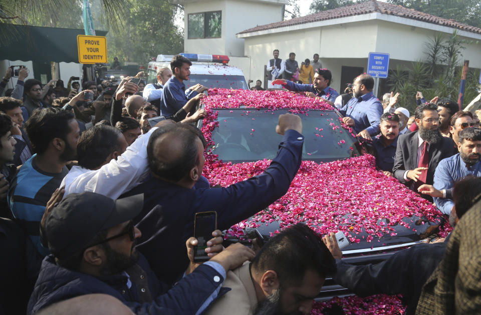 Supporters of Pakistan's ailing former prime minister Nawaz Sharif surround his vehicle at the airport in Lahore, Pakistan, Tuesday, Nov. 19, 2019. Sharif has arrived to board a special plane after a court permitted him to leave the country for four weeks abroad for medical treatment. (AP Photo/K.M. Chaudary)