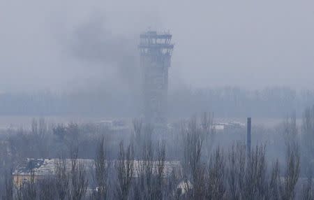 Smoke rises near the traffic control tower of the Sergey Prokofiev International Airport damaged by shelling during fighting between pro-Russian separatists and Ukrainian government forces, in Donetsk, eastern Ukraine, November 12, 2014. REUTERS/Maxim Zmeyev