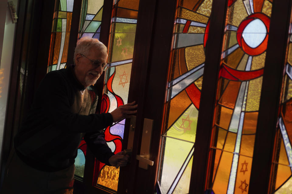 Steven Cohen, co-president of New Light Congregation, opens the stained-glass door of the New Light Memorial Chapel at the New Light Cemetery, on Wednesday, April 19, 2023, in Shaler Township, Pa. The chapel was built after the 2018 Pittsburgh synagogue massacre in part to honor the 11 worshipers who were lost from three congregations, Dor Hadash, New Light and Tree of Life. The stained glass, which was designed in collaboration with the New Light victims' families, is based on the Torah chapter that would have been read on the weekend of Oct. 27, 2018. (AP Photo/Jessie Wardarski)