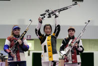Yang Qian, of China, holds her rifle aloft after winning a gold medal in the women’s 10-meter air rifle at the Asaka Shooting Range in the 2020 Summer Olympics, Saturday, July 24, 2021, in Tokyo, Japan. Anastasiia Galashina, left, of the Russian Olympic Committee, took the silver medal and Nina Christen, of Switzerland took the bronze medal.(AP Photo/Alex Brandon)