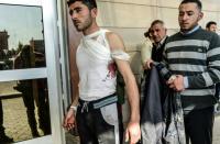 An injured Syrian man stands in front of Kilis hospital in south-central Turkey on February 15, 2016, arriving from northern Syria