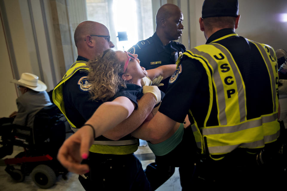 A demonstrator protesting cuts to Medicaid is carried away.&nbsp;