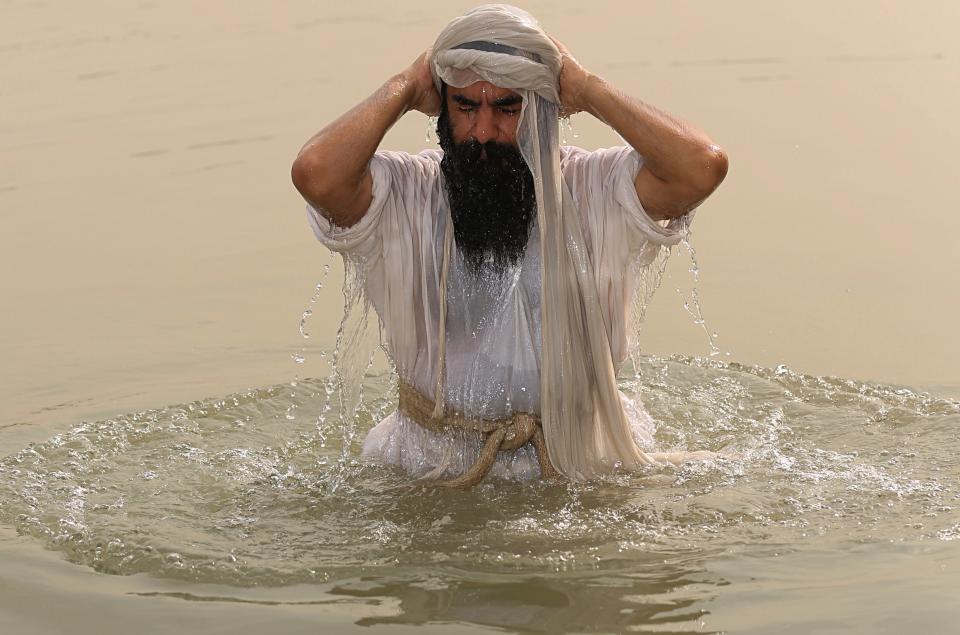 In this Sunday, Oct. 14, 2018 photo, a follower of the obscure and ancient Mandaean faith bathes along a strip of embankment on the Tigris River reserved for them, in Baghdad, Iraq. Iraq’s soaring water pollution is threatening the religious rites of its tight-knit Mandaean community, already devastated by 15 years of war that has also affected the country’s other minority Abrahamic sects. (AP Photo/Hadi Mizban)