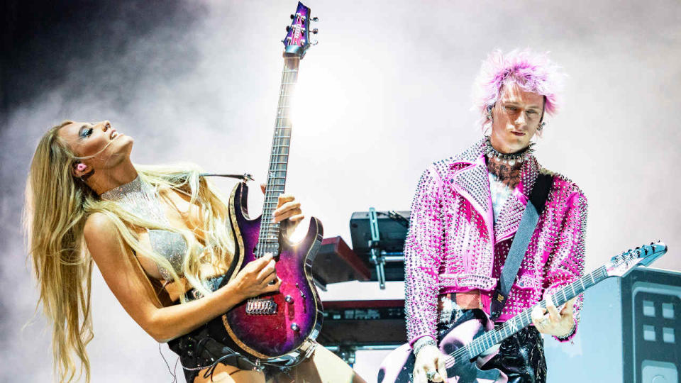 Sophie Lloyd playing guitar onstage with Machine Gun Kelly