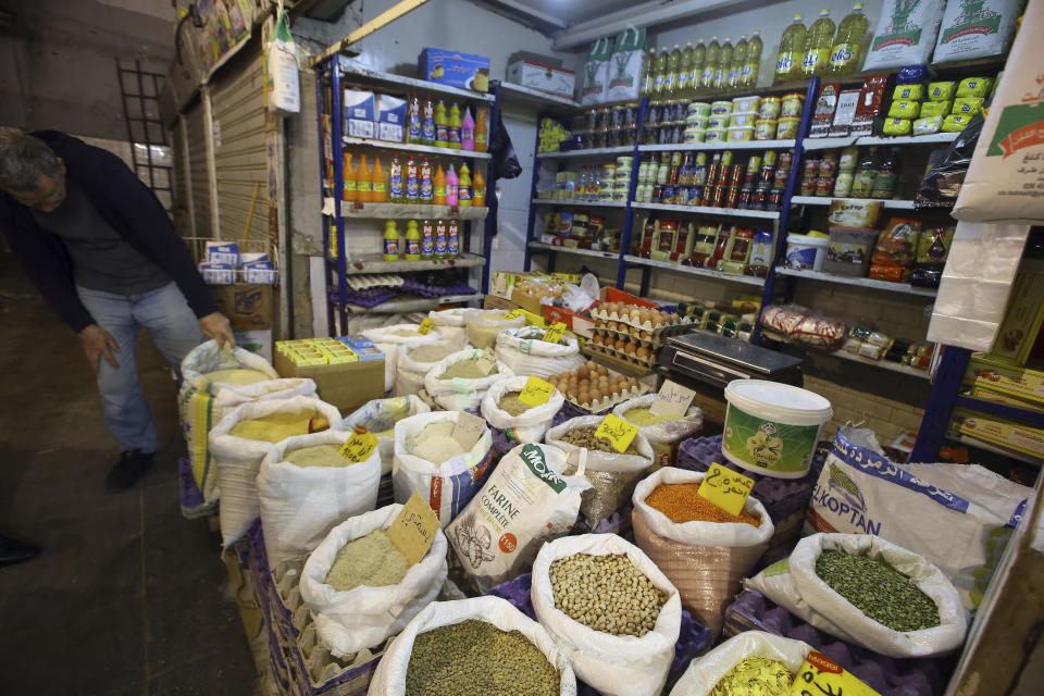 A man checks a bag in a market in Algiers, Tuesday, March 26, 2024. As Muslim-majority countries reckon with increased demand throughout Islam's holy month of Ramadan, is trying to flood new markets with pantry staples to stave off shortages that can cause prices to rise. (AP Photo/Anis Belghoul)