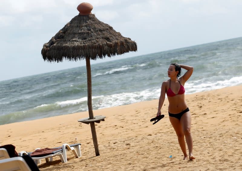 FILE PHOTO: A tourist walks on Paradise Beach in Colombo