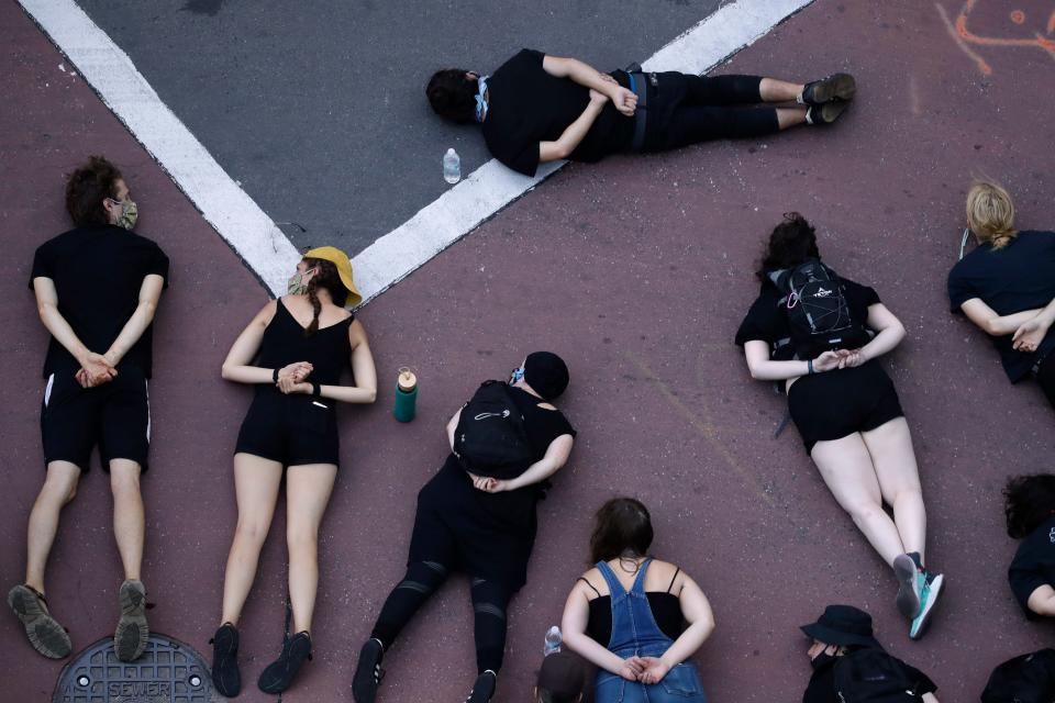 Protesters demanding police reforms and an end to Operation Legend lie in the street to block a downtown Kansas City, Missouri, intersection July 17, 2020.