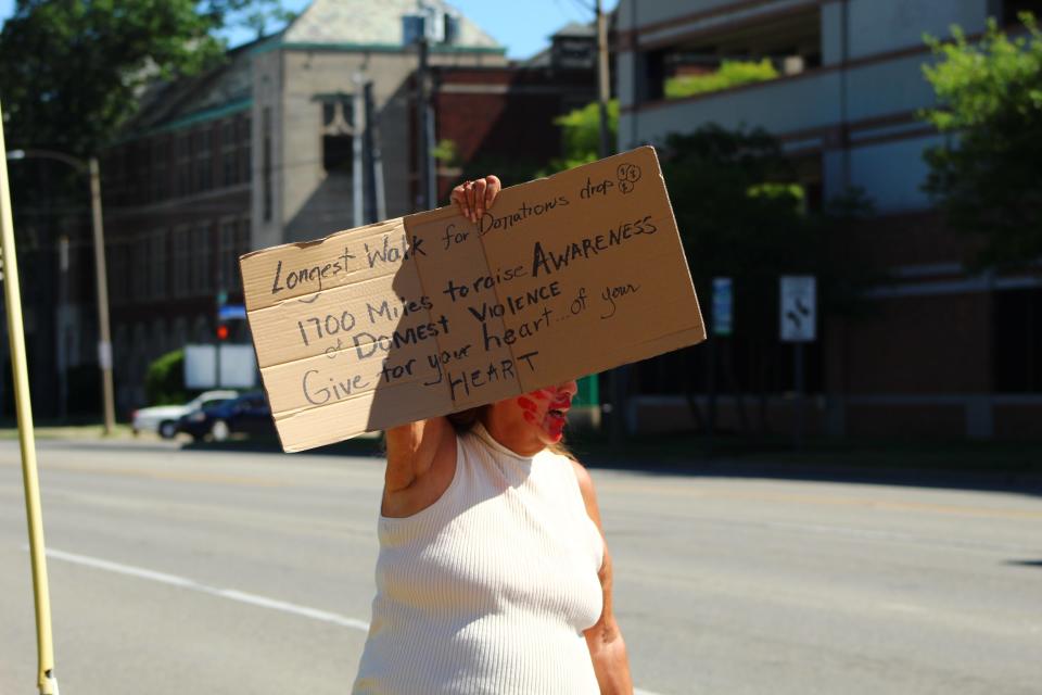 Jewell Chingman, citizen of the Little Traverse Bay Band of Odawa Indians, holds a sign for donations as part of the Longest Walk 5 on June 17, 2022, in Lansing.