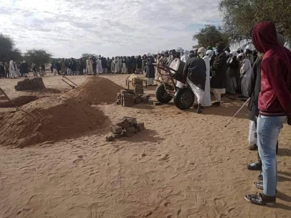 People gather as victims from a collapsed gold mine are buried on Tuesday, Dec. 28, 2021 in Kordofan, Sudan. The defunct mine collapsed earlier this week, killing several people. The Sudanese Mineral Resources Limited Company said the mine was not functional but local miners returned to work there after security forces guarding the site left the area. (Sudanese Mineral Resources Limited Company via AP)