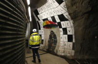 A man walks in a test and exploring tunnel for a Turin-Lyon high-speed rail (TAV) in Chiomonte, Italy, Tuesday, Feb. 12, 2019. The TAV project is part of a European wide network to improve high-speed rail connections. On the Italian side, the construction site long targeted by sabotaging protesters is guarded by four law enforcement agencies and has been reduced to maintenance work only. The survival of Italy's increasingly uneasy populist government could very well depend on whether Italy restarts construction on the TAV link, which it halted in June. (AP Photo/Antonio Calanni)