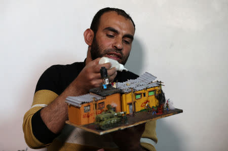 Palestinian diorama artist Majdi Abu Taqeya works on a miniature carved from remnants of Israeli ammunition collected from the scenes of border protests along the Israel-Gaza border, in the central Gaza Strip March 11, 2019. Picture taken March 11, 2019. REUTERS/Ibraheem Abu Mustafa