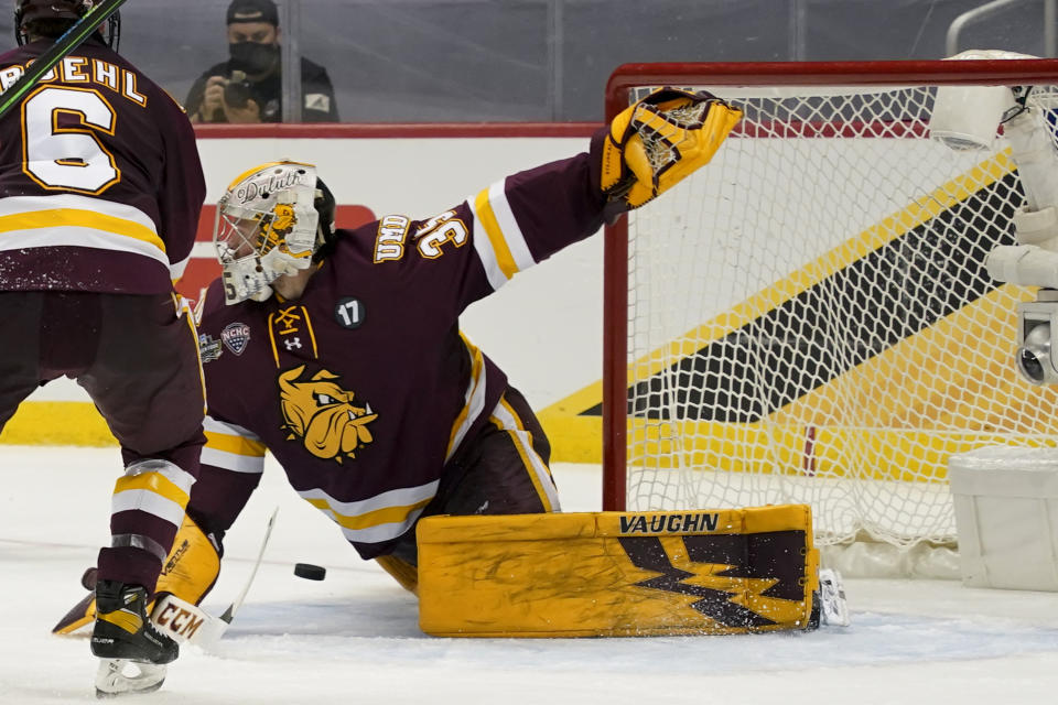 Minnesota Duluth goaltender Zach Stejskal (35) stretches to clear the puck against Massachusetts during the second period of an NCAA men's Frozen Four hockey semifinal in Pittsburgh, Thursday, April 8, 2021. (AP Photo/Keith Srakocic)