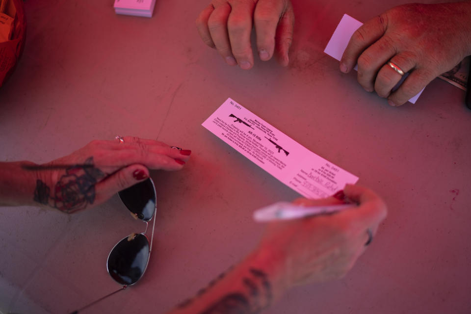 Barbie Rohde buys a raffle ticket to win an AR-15 rifle at a festival while volunteering for Mission 22, a nonprofit that is focused on ending military and veteran suicide, Saturday, June 10, 2023, in Jacksonville, Texas. Rohde is a conservative, a devoted fan of former President Donald Trump. She doesn’t like phrases like “gun control” and doesn’t believe in mandated gun restrictions. But something more needs to be done, she thinks. (AP Photo/David Goldman)