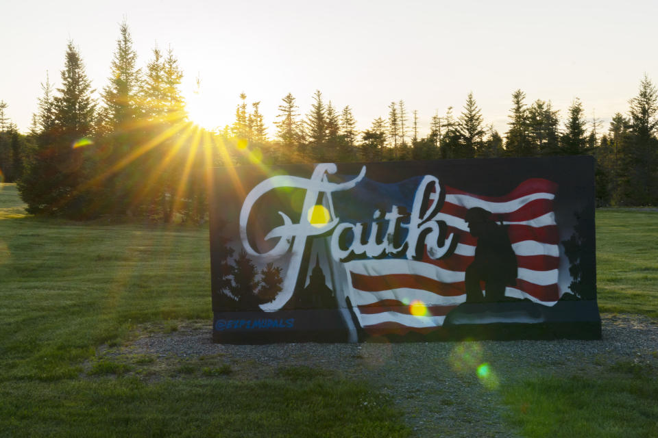 A mural stands at Patriot Park, a collection of monuments in tribute to veterans built by the Worcester family, in Columbia Falls, Maine, Saturday, May 27, 2023. The family hopes to build a $1 billion world's largest flagpole theme park nearby. (AP Photo/Robert F. Bukaty)
