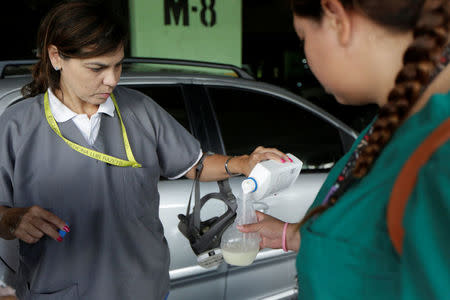 Volunteers pour stomach antacid into an atomizer with water as they get ready for help injured demonstrators in Caracas, Venezuela April 22, 2017. REUTERS/Marco Bello