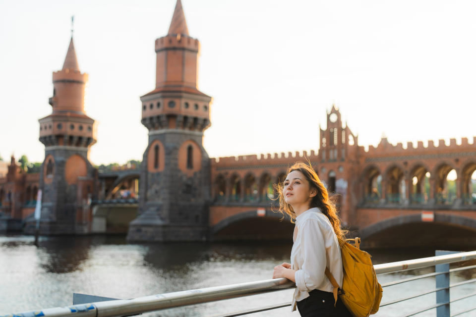 a woman standing in front of the oberbaumbrücke bridge in berlin