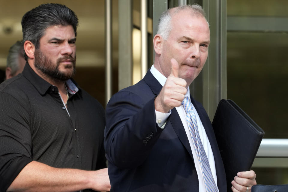 Michael McMahon, right, gives photographers a thumbs up as he leaves Brooklyn Federal court, May 31, 2023, in New York. McMahon, Zhu Yong and Zheng Congying are charged with being part of a continent-hopping conspiracy to hound a New Jersey man, his wife and their adult daughter. The couple had left their homeland and kept their U.S. address private. Yet eight years later, two strangers were banging on their New Jersey front door and twisting the handle, the wife testified in a U.S. court on Monday, June 5, 2023. (AP Photo/Mary Altaffer, File)