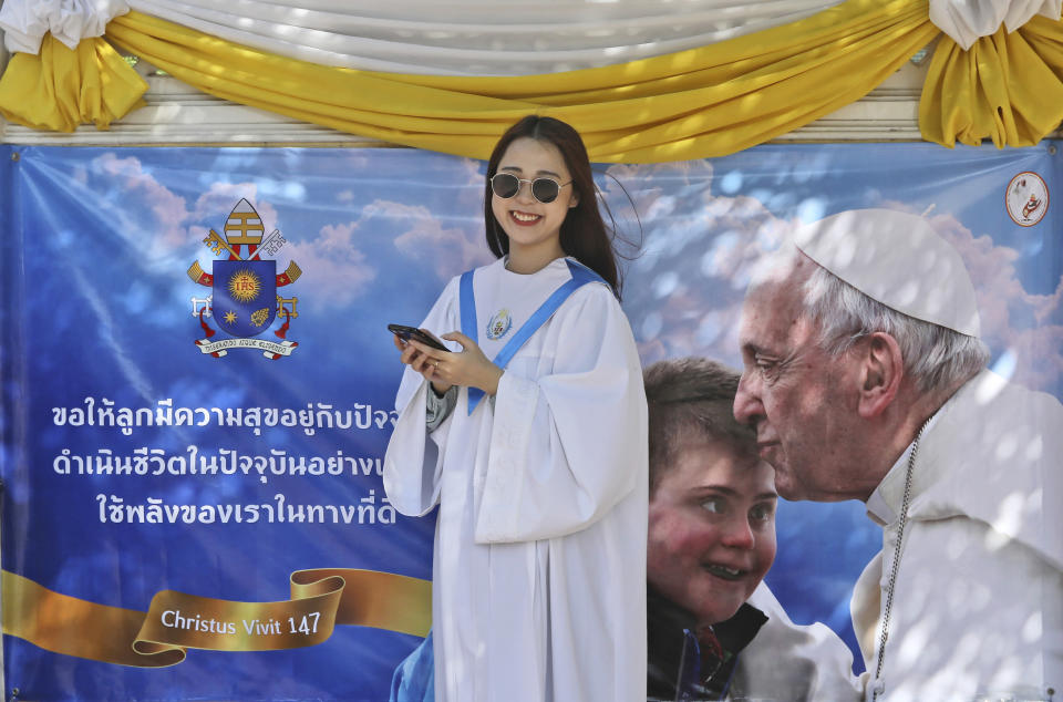 A Catholic girl from Vietnam poses in front of a poster with portraits of Pope Francis at the Assumption Cathedral in Bangkok, Thailand, Wednesday, Nov. 20, 2019. Pope Francis is heading to Thailand to encourage members of a minority Catholic community in a Buddhist nation and highlight his admiration for their missionary ancestors who brought the faith centuries ago and endured persecution. (AP Photo/Manish Swarup)
