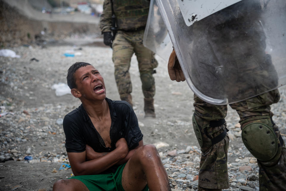 CEUTA, SPAIN - MAY 19: A migrant reacts as he talks to Spanish soldiers on the Tarajal beach after being intercepted when he was swimming across the border between Morocco and Spain on May 19, 2021 in Ceuta, Spain.  After a diplomatic conflict between Spain and Morocco, thousands of migrants who have taken advantage of the little Moroccan police activity on the border to cross it mainly by swimming, which has caused a migration crisis with the entry of more than 8000 migrants from the African country. (Photo by Joan Amengual/VIEWpress)