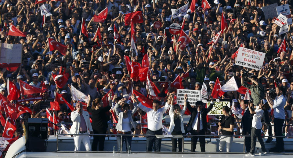 Ekrem Imamoglu, the new Mayor of Istanbul from Turkey's main opposition opposition Republican People's Party (CHP), center, salutes cheering supporters from a bus after he took over office, in Istanbul, Thursday, June 27, 2019. Imamoglu is formally taking office as mayor of Istanbul four days after he won a repeat election in Turkey's largest city and commercial hub. (AP Photo/Lefteris Pitarakis)