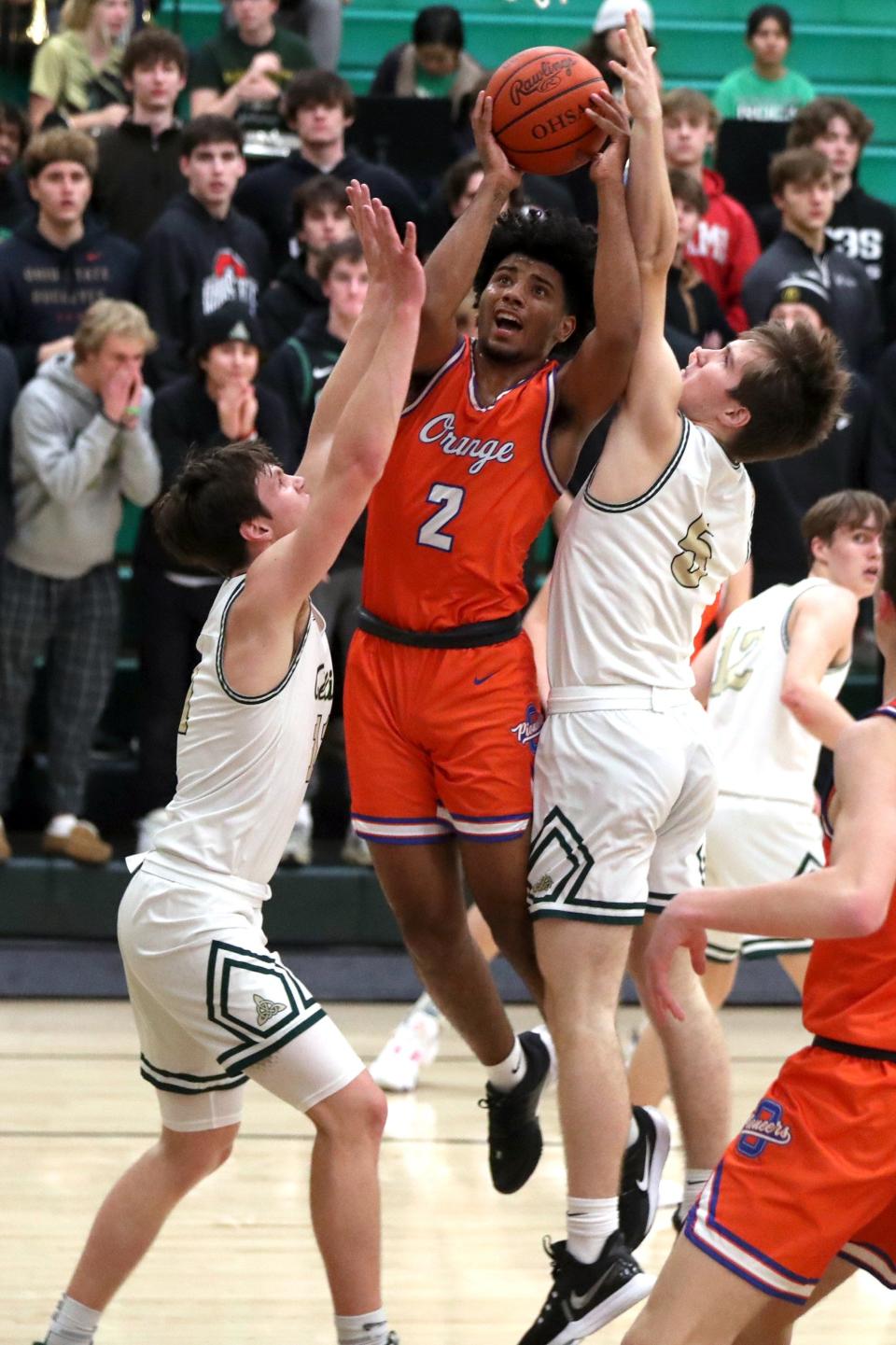 Olentangy Orange's Jordan Edwards goes to the basket between Dublin Jerome's Luke Kuhlman (11) and Brayden Krenzel (5) during a game Dec. 6. Orange won 55-45.