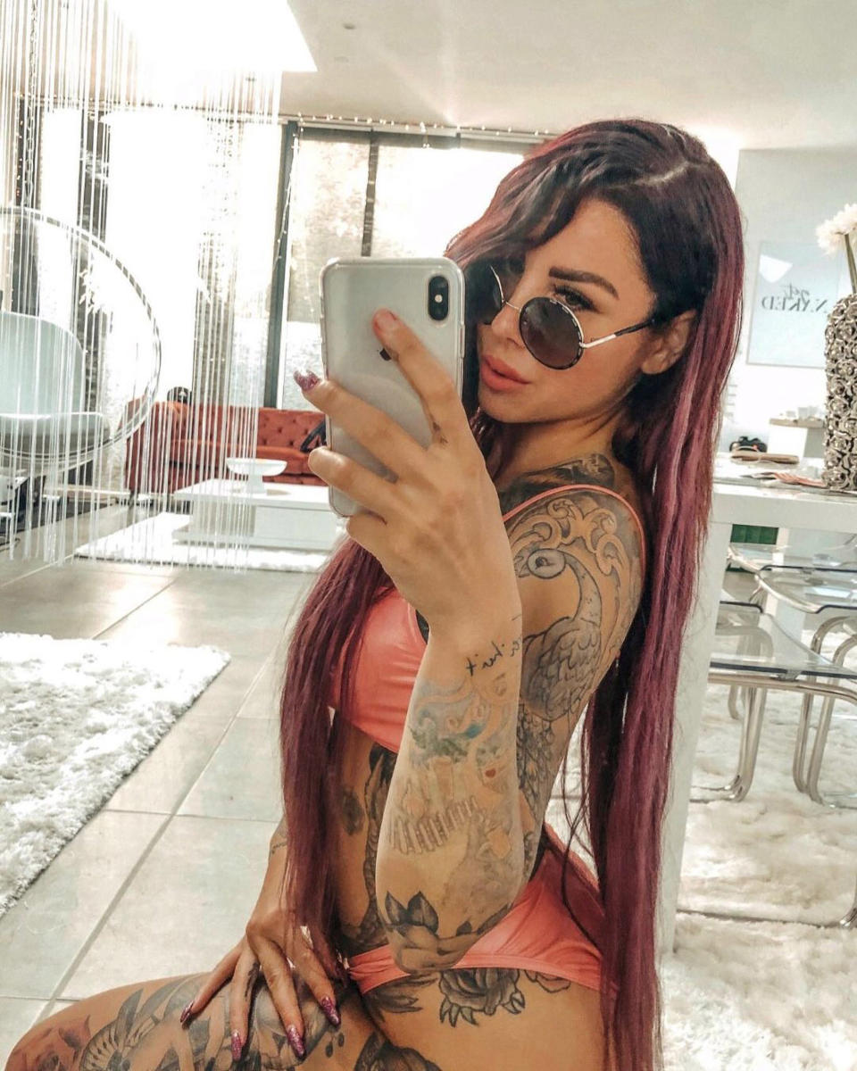 German influencer Kate Merlan wears a pink bikini while taking a selfie