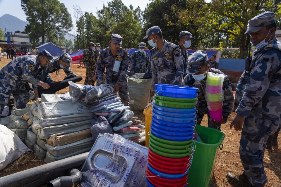 Policemen pack relief material to distribute among earthquake survivors in Jajarkot District, northwestern Nepal, Monday, Nov. 6, 2023. The Friday night earthquake in the mountains of northwest Nepal killed more than 150 people and left thousands homeless. (AP Photo/Niranjan Shrestha)