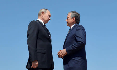 Russian President Vladimir Putin (L) speaks with Uzbek Prime Minister Shavkat Mirziyoyev after laying flowers at the grave of late Uzbek President Islam Karimov in Samarkand, Uzbekistan, September 6, 2016. Sputnik/Kremlin/Alexei Druzhinin/via REUTERS