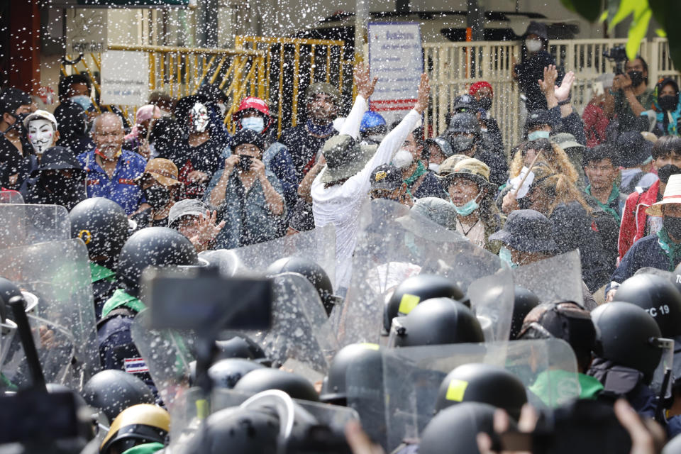 Protesters throw fermented fish sauce to riot police during a protest against the Asia-Pacific Economic Cooperation (APEC) forum, Friday, Nov. 18, 2022, in Bangkok Thailand. (AP Photo/Sarot Meksophawannakul)