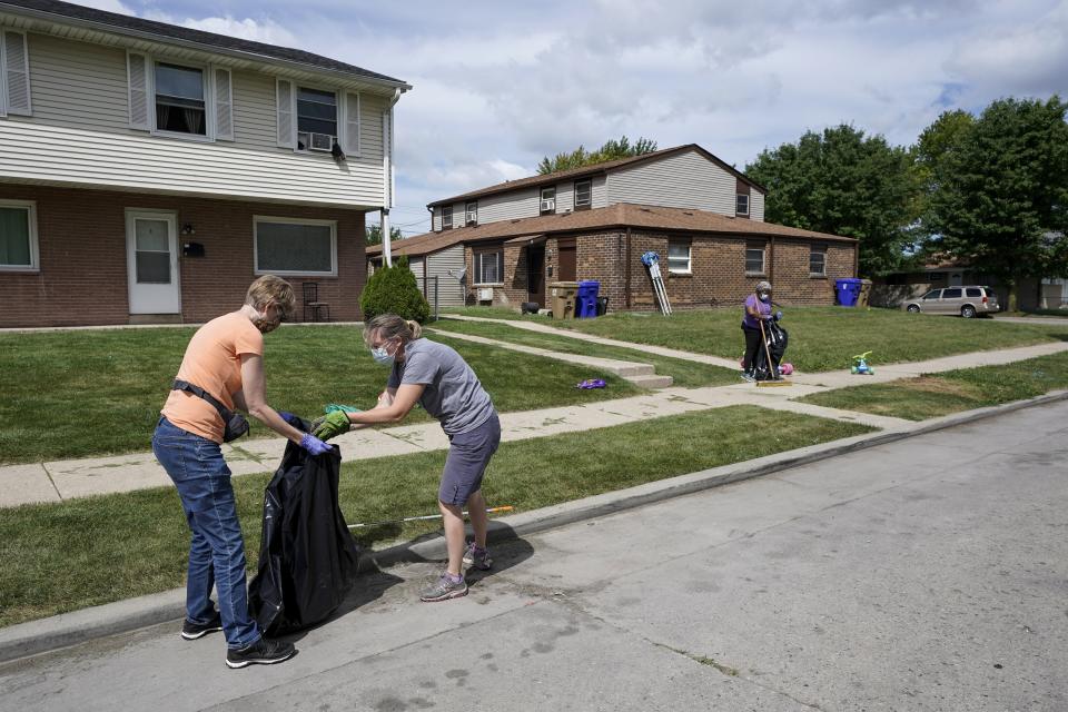 Church volunteers help clean up the neighborhood where Jacob Blake was shot last Sunday on Saturday, Aug. 29, 2020, in Kenosha, Wis. Family members of Jacob Blake, a Black man who was paralyzed after a Kenosha police officer shot him in the back, are leading a march and rally Saturday to call for an end to police violence. (AP Photo/Morry Gash)