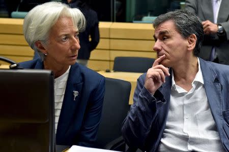 International Monetary Fund Managing Director Christine Lagarde (L) chats with Greek Finance Minister Euclid Tsakalotos during a euro zone finance ministers' meeting on the situation in Greece, in Brussels, Belgium, July 12, 2015. REUTERS/Eric Vidal